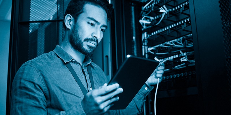 Server room, tablet and engineer with connection cable for maintenance or software update at night. Cybersecurity, it programmer and coder man with technology for database networking in data center.